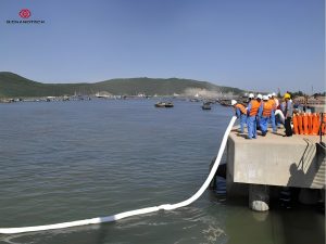 Workers using N-FIBER oil absorbent booms, port oil spill response, Bignanotech
