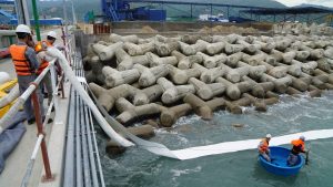 Oil Absorbent Roll containing a large oil spill in river 